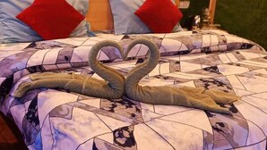 A bed with a quilt featuring a heart shape made from folded blankets. - Deodar Inn resort (Kalsi)