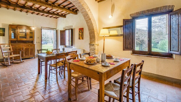 A rustic dining area with a wooden table, chairs, and a brick floor. - Family Tuscany Villa with private pool (Civitella in Val di Chiana)