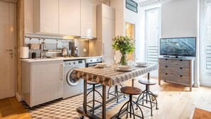 A modern kitchen with a central island, built-in appliances, and a dining area with stools. - #République#Paris2#Chatelêt#2bedrooms (Paris)