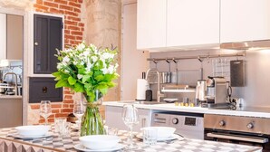 A modern kitchen with a checkered table set for dining, a vase of flowers, and stainless steel appliances. - #République#Paris2#Chatelêt#2bedrooms (Paris)