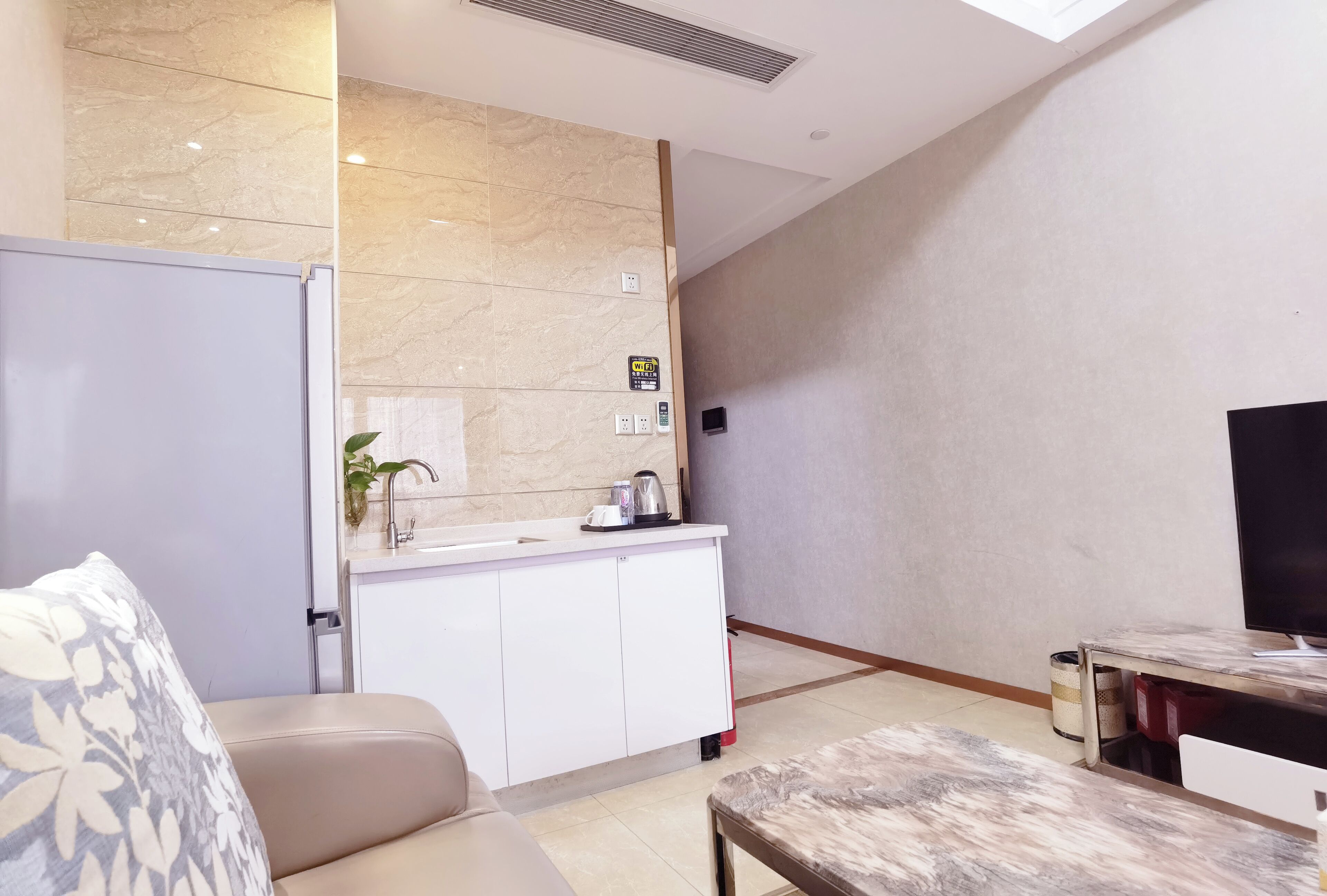 Uma sala de estar moderna com um sofá, uma mesa de centro e uma televisão.