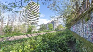A modern building with a unique architectural design, surrounded by greenery and a graffiti-covered wall. - New Duplex 6Pers#Paris Expo#Porte de Versailles (Paris)