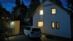 Et tosidet hus med hvide facader, en garage og en indkørsel.