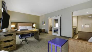 Une chambre d’hôtel avec un lit, un bureau, une chaise et une petite table.