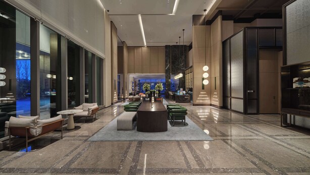 A modern lobby with a central seating area, large windows, and a high ceiling with recessed lighting. - Doubletree By Hilton Yanji (Yanbian)
