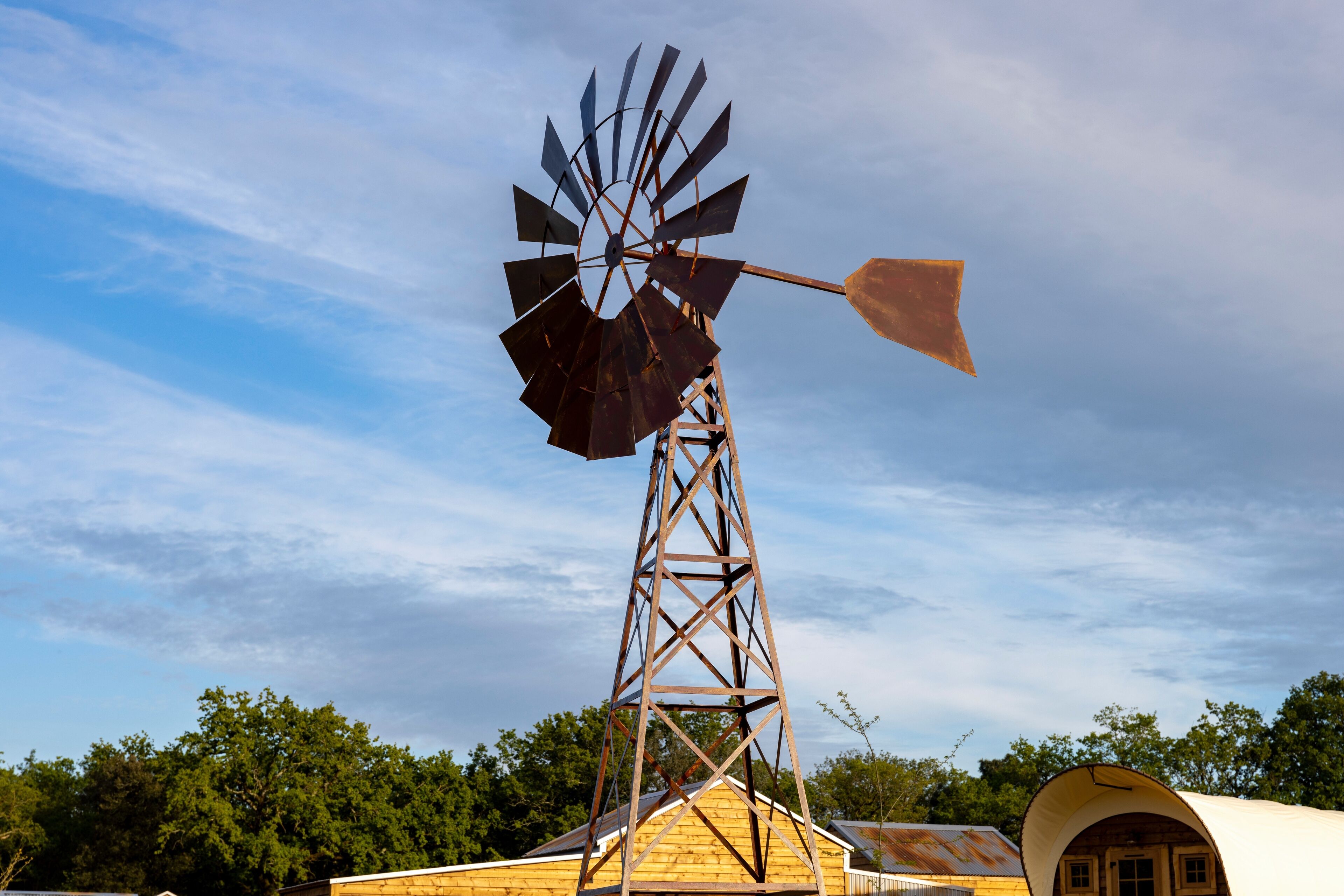 Een windmolen met een metalen constructie en een houten basis.