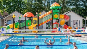 A swimming pool area with a play structure and adjacent cabins. - Holiday Home Near Bukowo Lake and Beach (Darlowo)