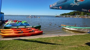 A lakeside with colorful kayaks docked and a Pepsi advertisement. - Holiday Home Near Bukowo Lake and Beach (Darlowo)