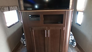 Un téléviseur fixé à un meuble dans un véhicule récréatif.