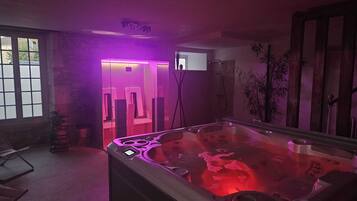 Relax in a serene space with a hot tub and shower, surrounded by lush views.