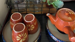 Un comptoir de cuisine avec un service à thé comprenant une théière, des tasses et un sucrier.