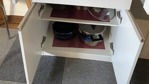 Un meuble de cuisine doté de plusieurs étagères contenant divers ustensiles et accessoires de cuisine.