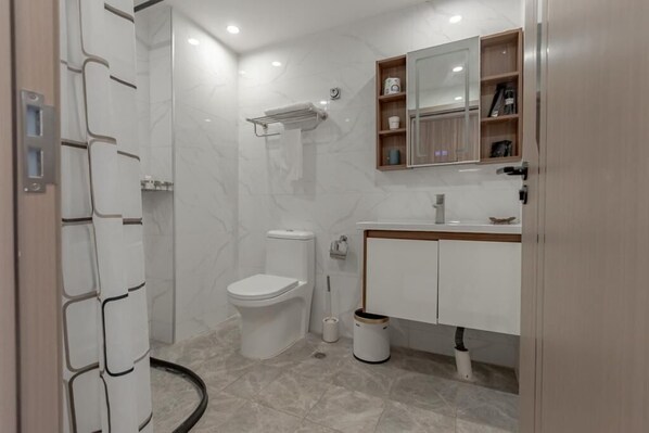 A modern bathroom with a toilet, sink, and shower.