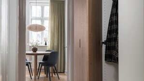 Un pasillo con piso de madera que conduce a un comedor con mesa y sillas.