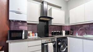 Una cocina moderna equipada con microondas, horno, lavavajillas y una campana extractora negra.