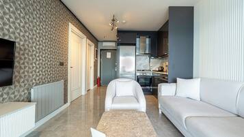 Suite ejecutiva, 1 cama King size, vista al mar | Sala de estar | Televisión LCD de 100 pulgadas con canales digitales