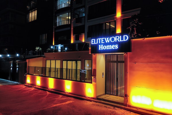 A building with a sign reading "ELITEWORLD Homes" at night. - Elite World Homes Istanbul Bosphorus (Istanbul)