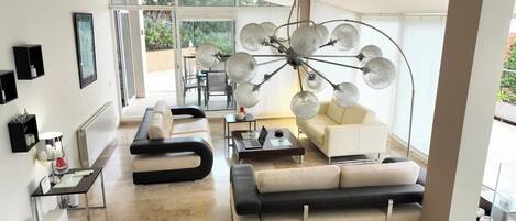 A modern living room with a sofa, coffee table, and a unique spherical chandelier.