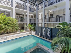 A multi-level building with a swimming pool, balconies, and greenery. - Luxury 3-bed oceanfront haven featuring a rooftop terrace with a private spa (Tweed)