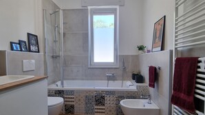 Ein modernes Badezimmer mit Dusche, Badewanne und zwei Waschbecken.