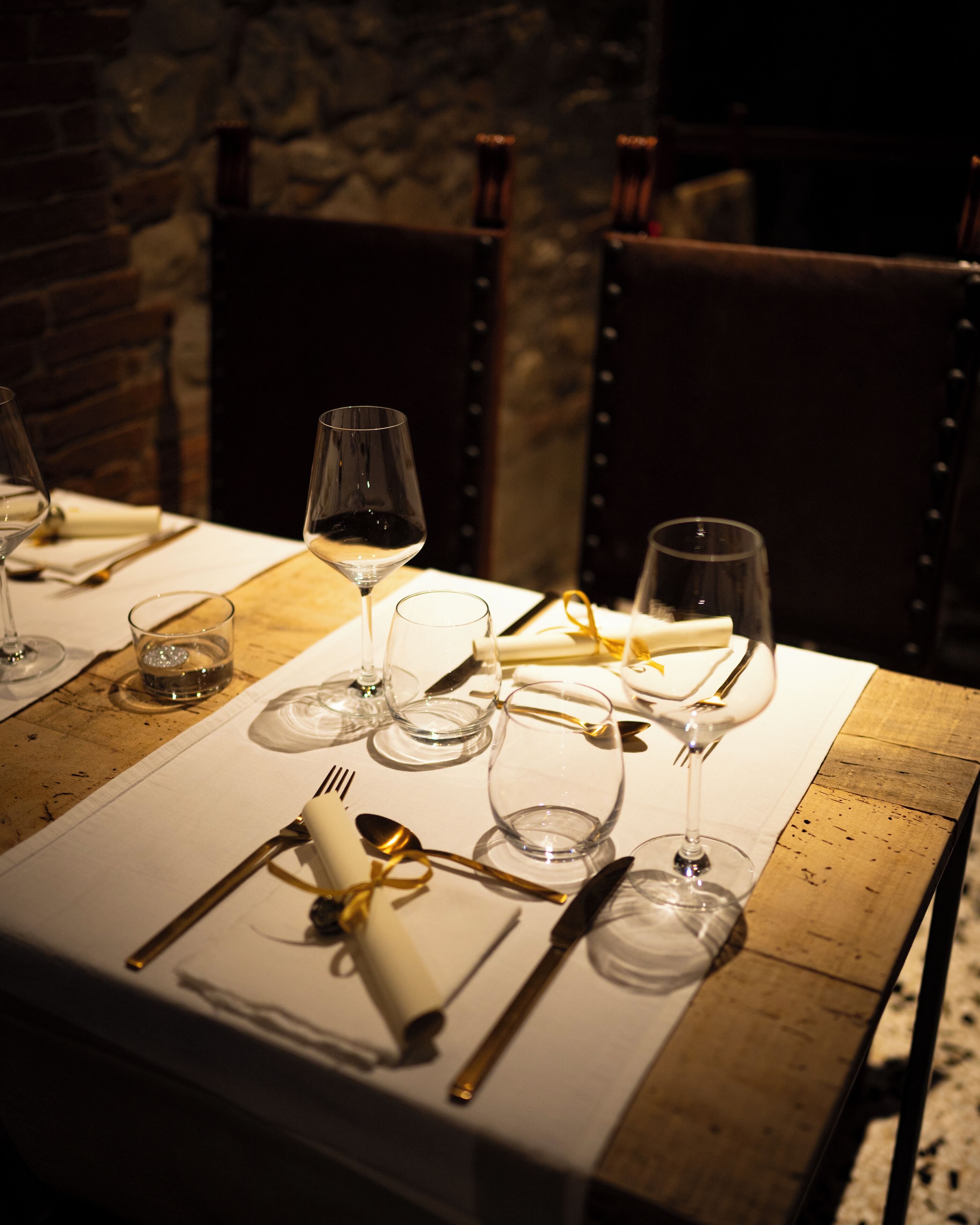 A table set for dining with wine glasses, cutlery, and a glass of water.