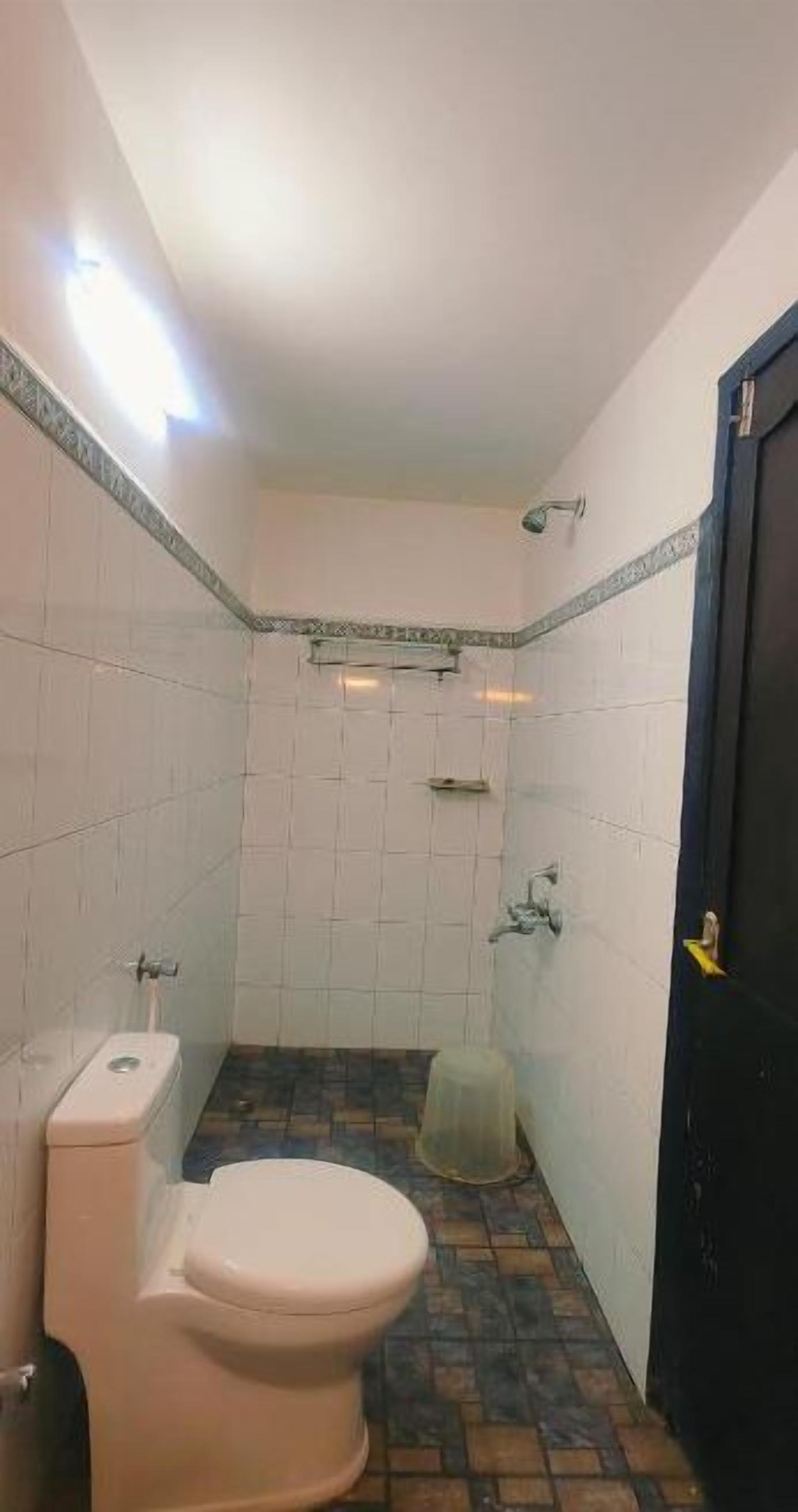 A small bathroom with a toilet, a shower, and a sink.