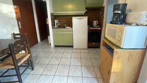 A compact kitchen with a refrigerator, microwave, coffee maker, and a small oven. - Argelès T2 beach, park, parking, 4 pers (Argelès-sur-Mer)