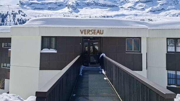 Ein Gebäude namens 'VERSEAU' mit einem überdachten Zugang zur Eingangstür.