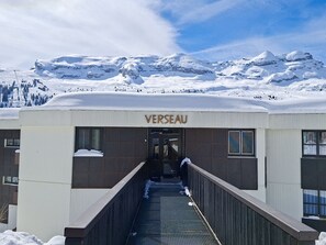 Un edificio llamado 'VERSEAU' con un paseo techado que lleva a la entrada.