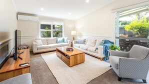 A modern living room with two sofas, a coffee table, and a TV. - Geelong Road (Barwon Heads)