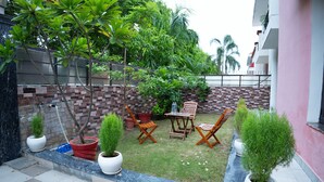 Une terrasse agrémentée de plantes en pot, de meubles d’extérieur et d’un mur en briques.