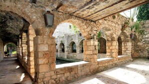An ancient stone structure with arches and a paved pathway. - Superior apartment in Stari Grad (Stari Grad)