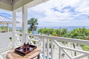 A balcony with a view of the ocean and palm trees. - Hospitality Expert - Little Waters Villa Negril (Negril)