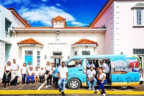 A group of people in front of a building with a sign that reads "HOSPITALITY EXPERT."