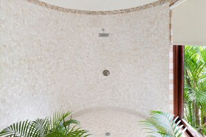 A circular jacuzzi with mosaic tile walls, a showerhead, and a drain. - Hospitality Expert - Little Waters Villa Negril (Negril)