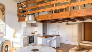 A modern kitchen with a wooden ceiling, a marble dining table, and a fur rug. - Rue du Centre | Bright duplex near Montreux train station (Montreux)