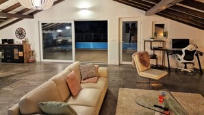 A spacious living area with a high ceiling, a sofa, a glass table, and a TV. - Cool 3-bedroom house with AC in charming Praputnjak (Hreljin)