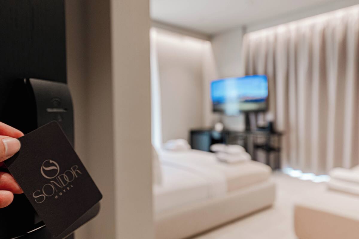 A hotel room with a bed, a television, and a minibar.