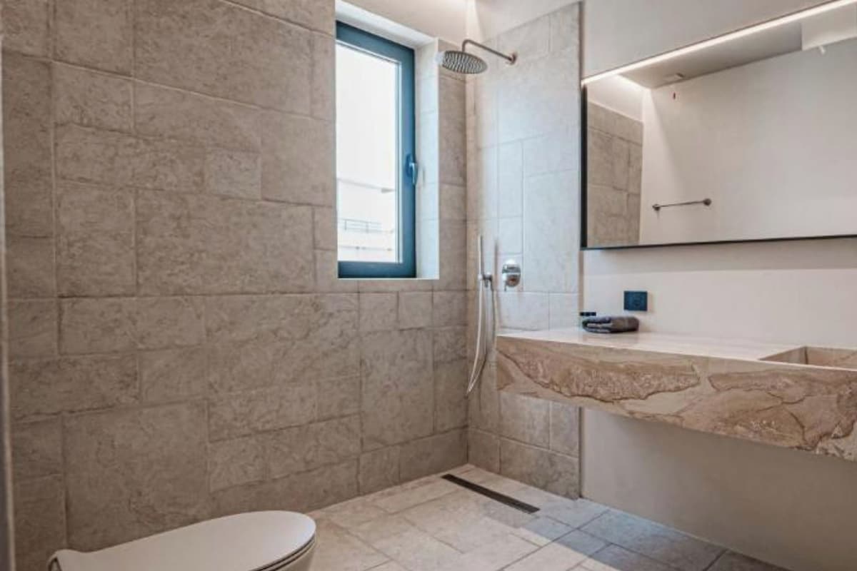 Un baño moderno con una bañera independiente, ducha y tocador con espejo.
