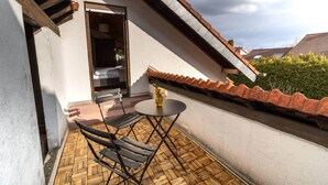 Un balcon avec un plancher en bois, une table et deux chaises.