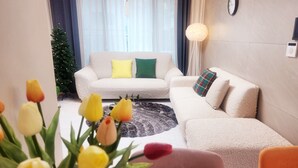 Ein modernes Wohnzimmer mit einer Sofagarnitur, einem Couchtisch und einer Tulpenvase.