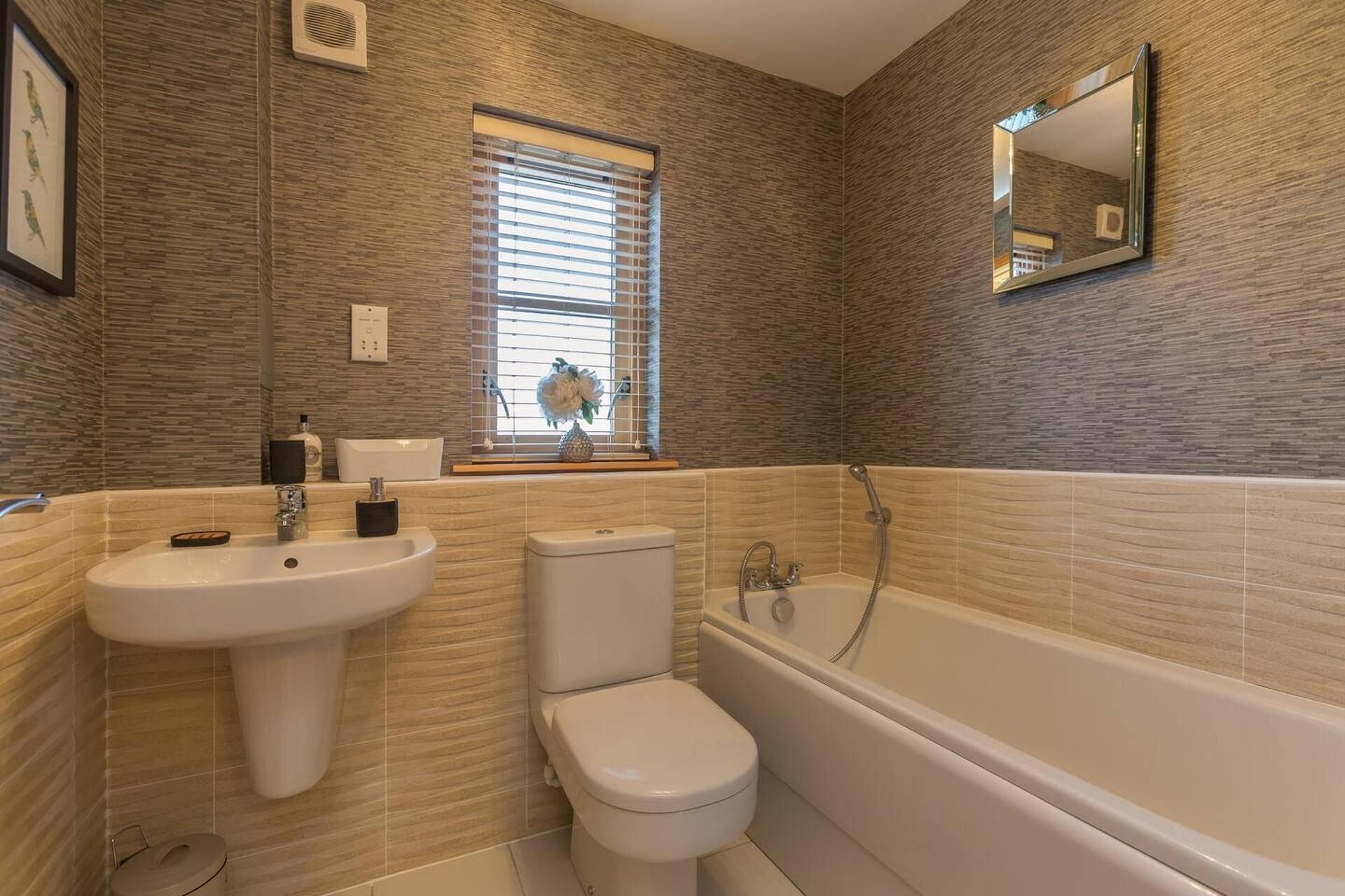 Un baño con lavamanos, inodoro y bañera.