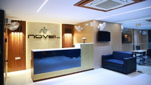 A modern reception area with a reception desk, a blue sofa, and a large aquarium.