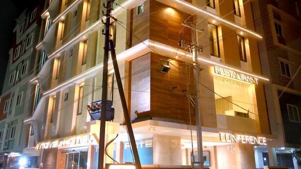 A multi-story hotel with a modern design, featuring a prominent 'RESTAURANT' sign on the ground floor and a 'CONFERENCE' sign on the second floor.