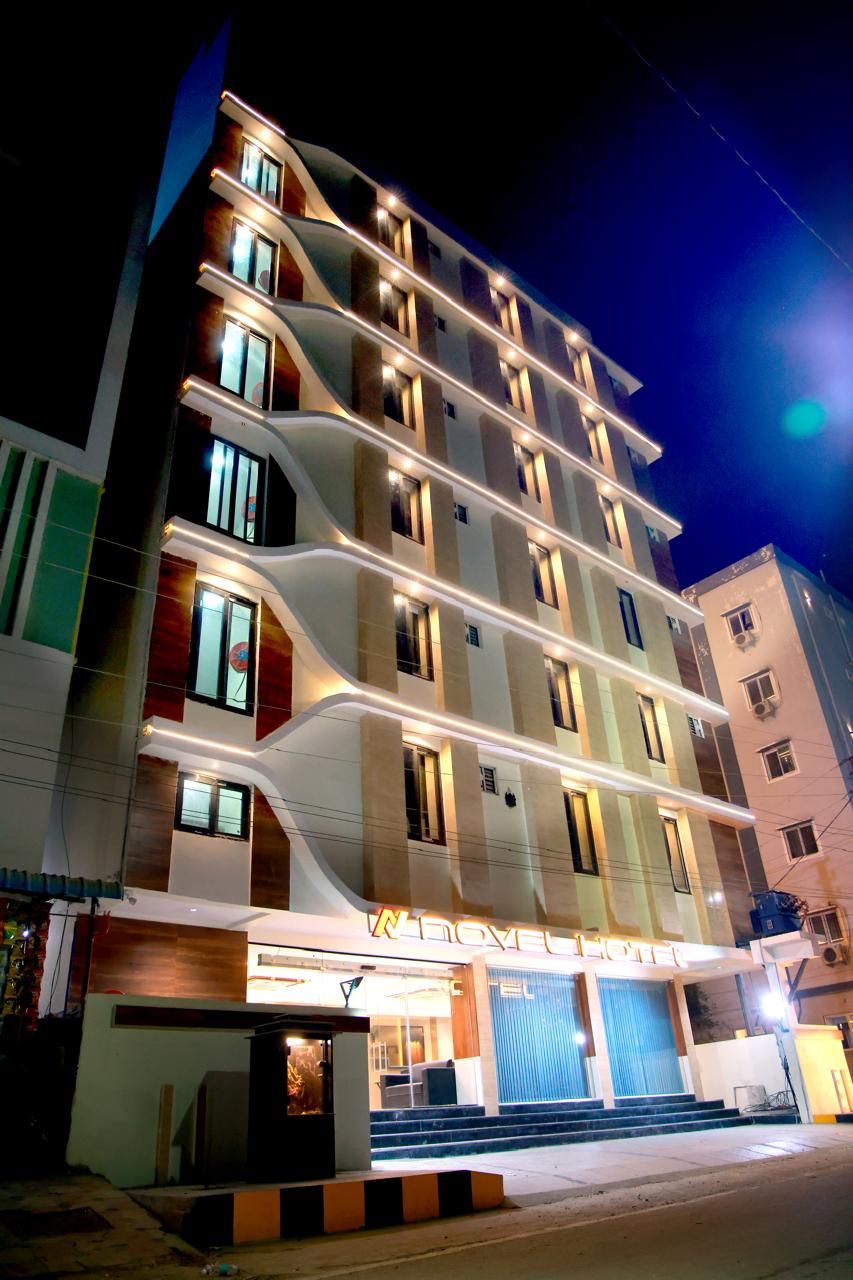 A multi-story hotel with a modern design, featuring a prominent entrance with steps and a glass facade.