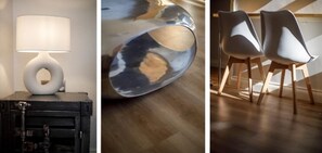 Modern interior design features a sleek lamp, metallic sculpture, and minimalist chairs.