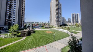 Zona residencial con edificios altos, césped cuidado y cielo despejado.