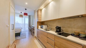 Una cocina moderna con armarios de madera, microondas integrado y cafetera.
