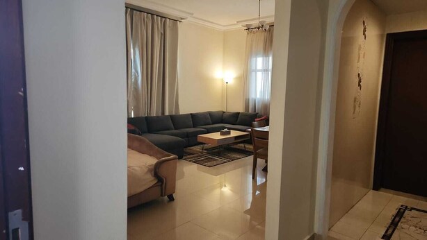 Ein Wohnzimmer mit einer Couch, einem Couchtisch und einer Lampe.