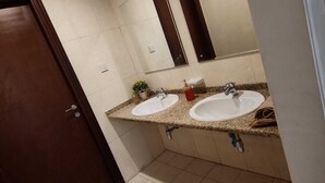 Ein Badezimmer mit zwei Waschbecken, einem Spiegel und einem Handtuchhalter.